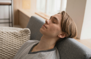 5 Simple Ways to Do a Vagus Nerve Reset at Home Young man relaxing on sofa for stress relief